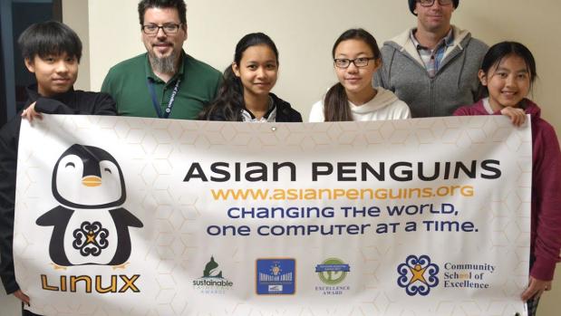 members of asian penguins student group, standing with a white banner held in front of them